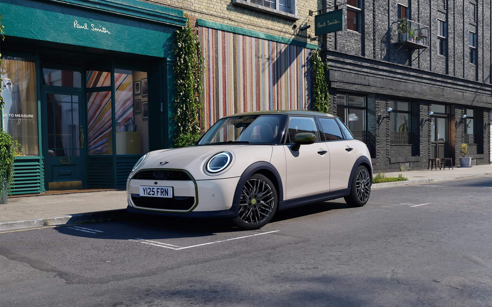 MINI 5-Türer Paul Smith Edition mit hellem Exterieur und dunklem Dach vor einem Paul Smith Store in der Stadt.