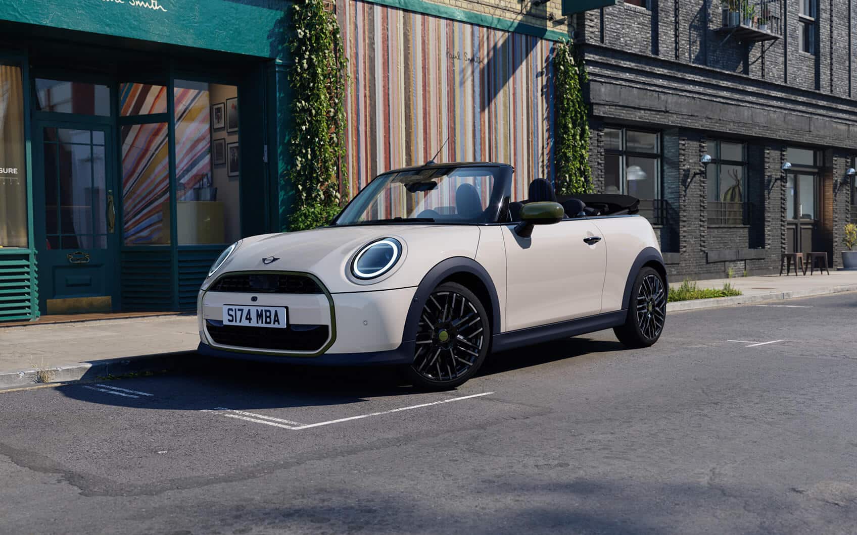 MINI Cabrio Paul Smith Edition mit hellem Exterieur und geöffnetem Verdeck vor einem Paul Smith Store in der Stadt.